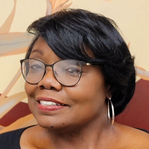 Christe Davis is an African-American woman. Her head is turned in three-quarter profile. She has short hair, and wearing medium sized ear rings.